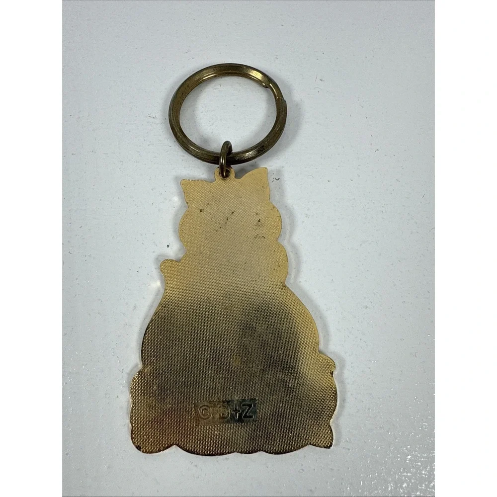 Black cat enamel keychain with gold-toned metal accents and‎ a red bow